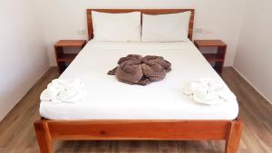 a bed with white sheets and flowers on it at Positano Alona Beach Panglao in Panglao