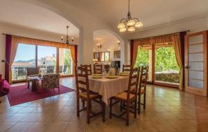 a dining room with a table and chairs and windows at Holiday House Klarin with Sea View in Preko
