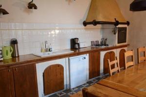 FranquevauxにあるAncienne Abbaye de Franquevaux Templiersのキッチン(木製キャビネット、白い食器洗い機付)