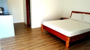 a bed in a room with a wooden floor at Positano Alona Beach Panglao in Panglao
