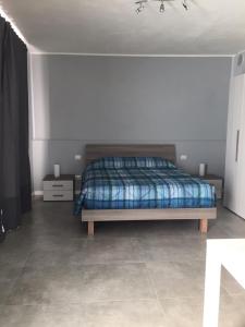 1 dormitorio con 1 cama con manta azul en Il Caravaggio Guest House, en Grassobbio