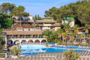 um resort com uma grande piscina com espreguiçadeiras em Frantheor Fréjus 5 étoiles em Fréjus