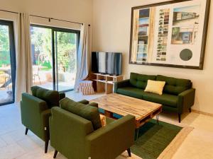 a living room with two green couches and a table at Mas Notre Dame in Eygalières