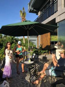 a group of people sitting around a table under an umbrella at Saipan Skyline Designers Hotel in Saipan