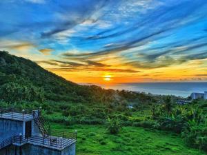 a sunset over the ocean from a hill at Saipan Skyline Designers Hotel in Saipan