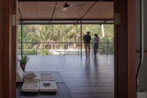 a man and woman standing on a porch looking out at the view at Baan Lek Villa in Chanthaburi