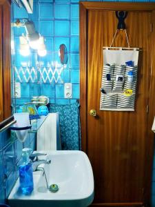 uma casa de banho com um lavatório e uma parede de azulejos azuis em Alicante Room and gayfriendly em Alicante