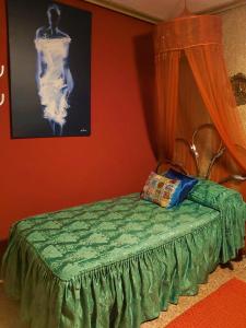 a bedroom with a green bed with a painting on the wall at Alicante Room and gayfriendly in Alicante