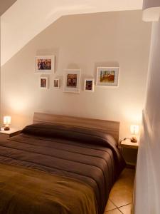 una camera da letto con un letto con immagini appese al muro di Casa Etna a Catania