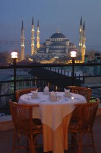 a table on a balcony with a view of a mosque at Hali Hotel in Istanbul