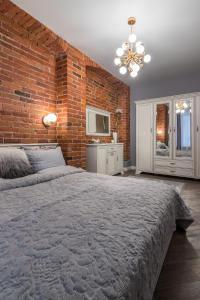 a bedroom with a brick wall and a large bed at Dandelion apartment in the heart of Kaunas in Kaunas