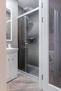 a bathroom with a shower with a glass door at Dandelion apartment in the heart of Kaunas in Kaunas