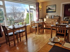 a dining room with tables and chairs and a large window at Cranford Guest House in Braemar