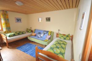 una pequeña sala de estar con sofá y cama en Greussinghof, en Lauterach