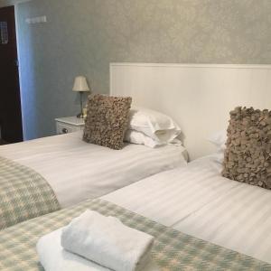 dos camas sentadas una al lado de la otra en una habitación en Littletown Farm Guest House en Keswick