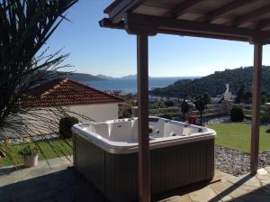 a hot tub under a pergola with a view of the ocean at Agnantema Villas in Aghios Petros Alonissos