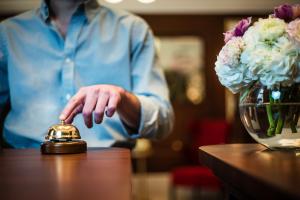 una persona está sentada en una mesa con una campana en The Merchant Baku, en Baku