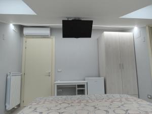 a bedroom with a bed and a flat screen tv at DADA in Giffoni Valle Piana
