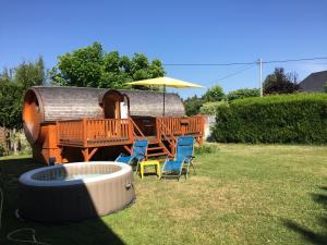 a yard with chairs and a house with an umbrella at Gîte Chais Catherine in Amboise