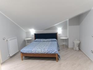 1 dormitorio con 1 cama con edredón azul y 2 mesas en DADA, en Giffoni Valle Piana