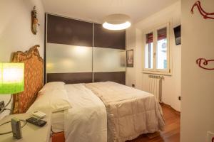 a bedroom with a bed and a table and a window at Realkasa Senzanome Flat in Bologna