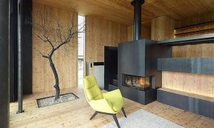 a living room with a yellow chair and a fireplace at Weingarthaus in Gamlitz