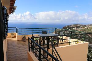 Un balcón con mesa y vista al mar. en Casa Bela Vista, en Ribeira Brava