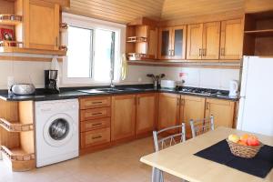 a kitchen with a washing machine and a table at Casa Bela Vista in Ribeira Brava