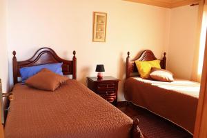 Un dormitorio con dos camas y una mesa con lámpara. en Casa Bela Vista, en Ribeira Brava