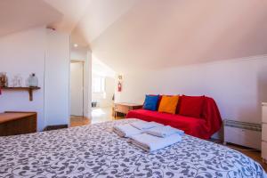 - une chambre avec un lit et un canapé rouge dans l'établissement Nice View Apartment Bairro Alto, à Lisbonne