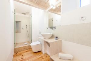 a white bathroom with a sink and a toilet at GuestReady - Beco do Garcês Apartment in Lisbon