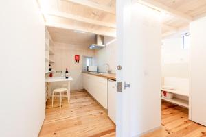 a kitchen with white cabinets and a wooden floor at GuestReady - Beco do Garcês Apartment in Lisbon