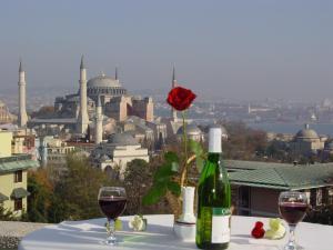 a table with two glasses of wine and a rose at Hali Hotel in Istanbul
