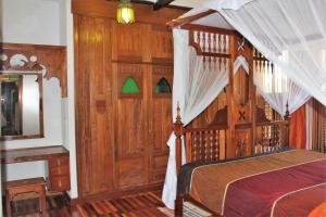 1 dormitorio con cama con dosel y espejo en The King Post, en Nairobi