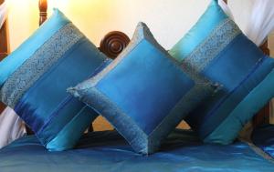 três almofadas azuis sentadas em cima de uma cama em The King Post em Nairobi