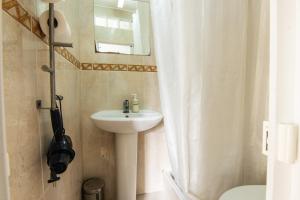 ein Badezimmer mit Waschbecken und Spiegel in der Unterkunft Apartamento Bairro Alto in Lissabon + 4 Fotos