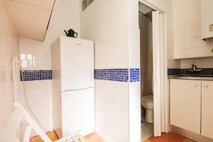 ein Badezimmer mit einem weißen Kühlschrank und einem WC in der Unterkunft Apartamento Bairro Alto in Lissabon
