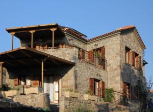 a large stone house with balconies on the side of it at Grand View Afrodite in Mithymna