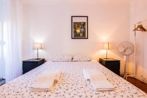 リスボンにあるApartamento Bairro Altoのベッドルーム1室(大型ベッド1台、ランプ2つ付)