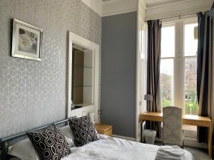 a bedroom with a bed and a window and a desk at Northumberland Hotel in Edinburgh