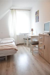 a bedroom with a bed and a desk with a computer at Weranda in Wdzydze Kiszewskie