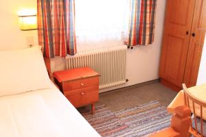 Schlafzimmer mit einem Bett, einem Schreibtisch und einem Fenster in der Unterkunft #hostFLACHAU1 in Flachau