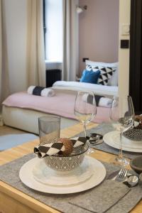 Una mesa con un plato de comida y copas de vino. en Luxury City Center Apartments close to National Theater, en Zagreb