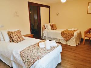 a hotel room with two beds and a chair at The Old Stables self catering in Salisbury