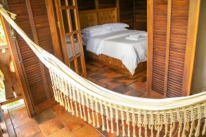 a hammock in a room with a bed at Hotel Fazenda Igarapés in Igarapé