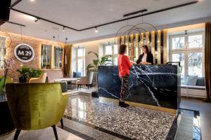 two people standing at a counter in a restaurant at Hotel M29 in Kraków