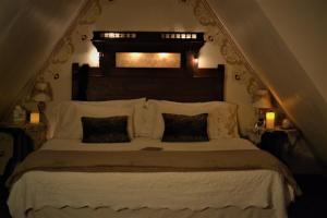 a bedroom with a large bed with white sheets and pillows at Carleton House Bed and Breakfast in Bonham