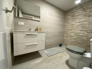 a bathroom with a toilet and a sink at WISH SUITE NIEBLA DE SEVILLA in Seville