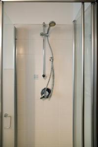 La salle de bains est pourvue d'une douche avec un pommeau de douche. dans l'établissement Ballatoio Apartment by the Lake, à Lesa