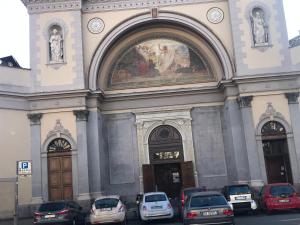 una grande chiesa con macchine parcheggiate di fronte di Casa Serena a Torino
